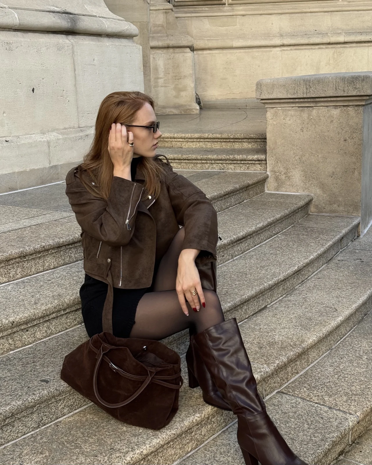 Stella in a brown suede jacket on stone steps